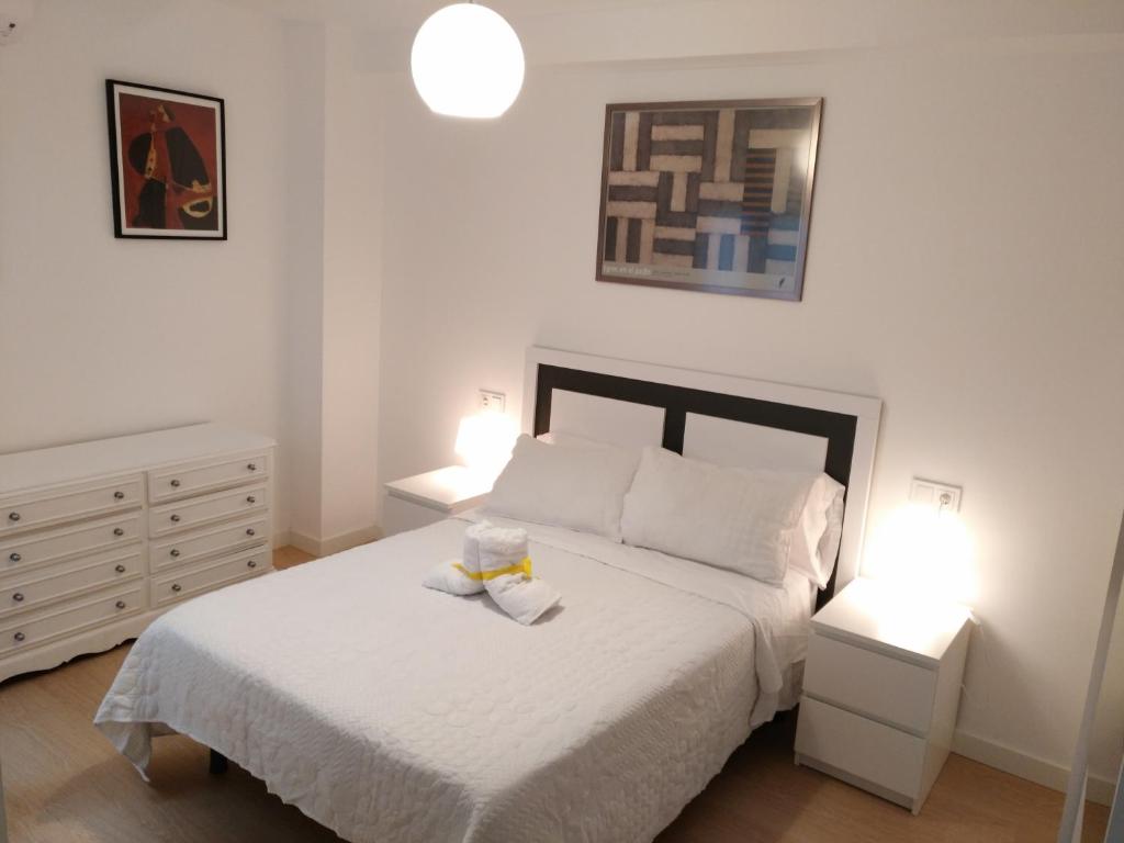 1 dormitorio con 1 cama blanca y 2 mesitas de noche en Lavadero de la Cruz, en Granada