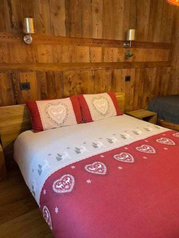a bedroom with a bed with a red blanket at Lo Péyo Avise in Avise