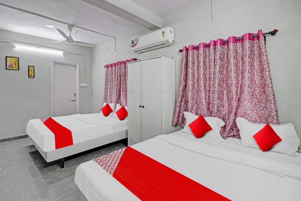 two beds in a room with red and white at Hotel O Moonlight Inn in Nagpur