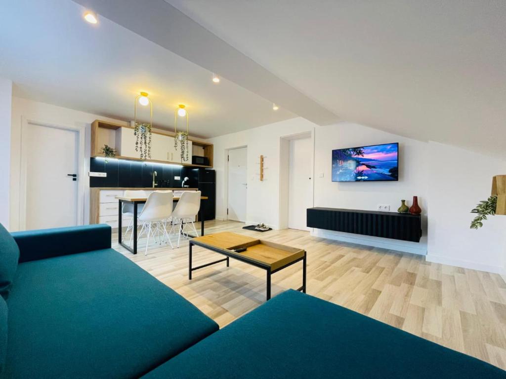 a living room with a blue couch and a table at Vila Morariu in Bistriţa