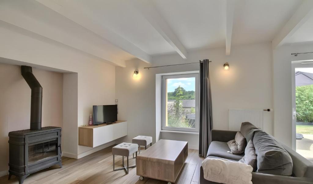 a living room with a couch and a fireplace at Gite Baie 3km plages in Telgruc-sur-Mer