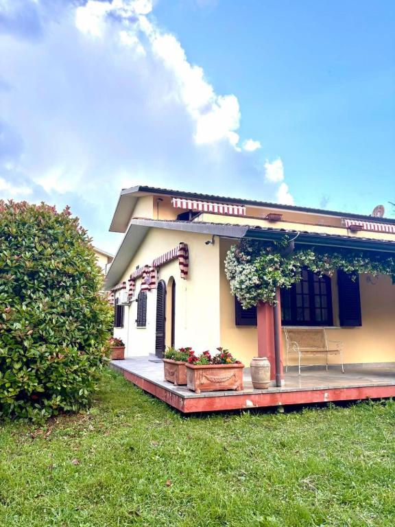 a small house with a porch and a lawn at Villa Felicità in Lucca