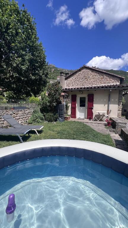 a swimming pool in front of a house at Gîte du Riou Sec in La Roque-Sainte-Marguerite