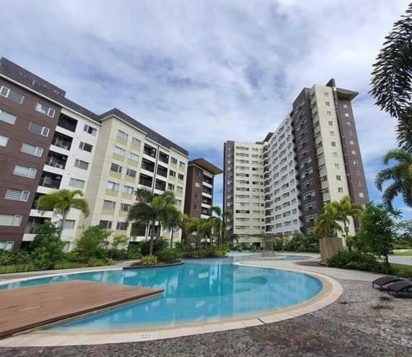 a swimming pool in the middle of two buildings at Comfy condo convenient location in Iloilo City