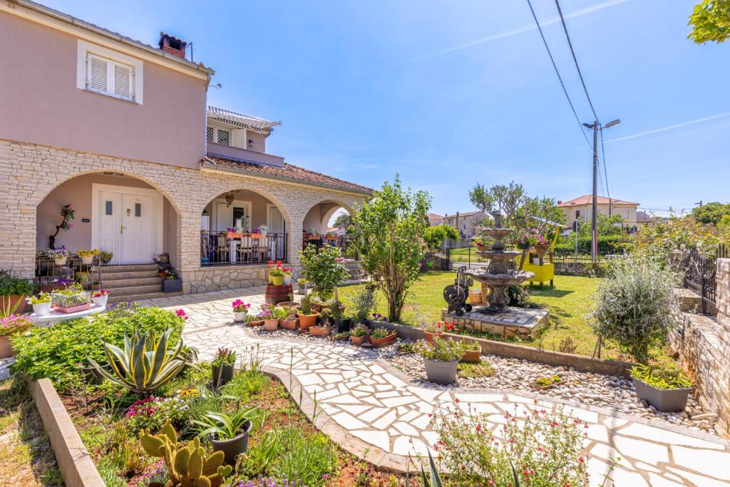 a garden in front of a house with plants at Apartman Mely in Nova Vas