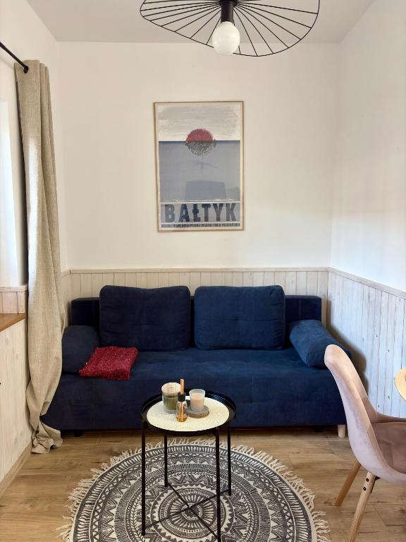 a blue couch in a living room with a table at Apartament Wichrowy in Rowy