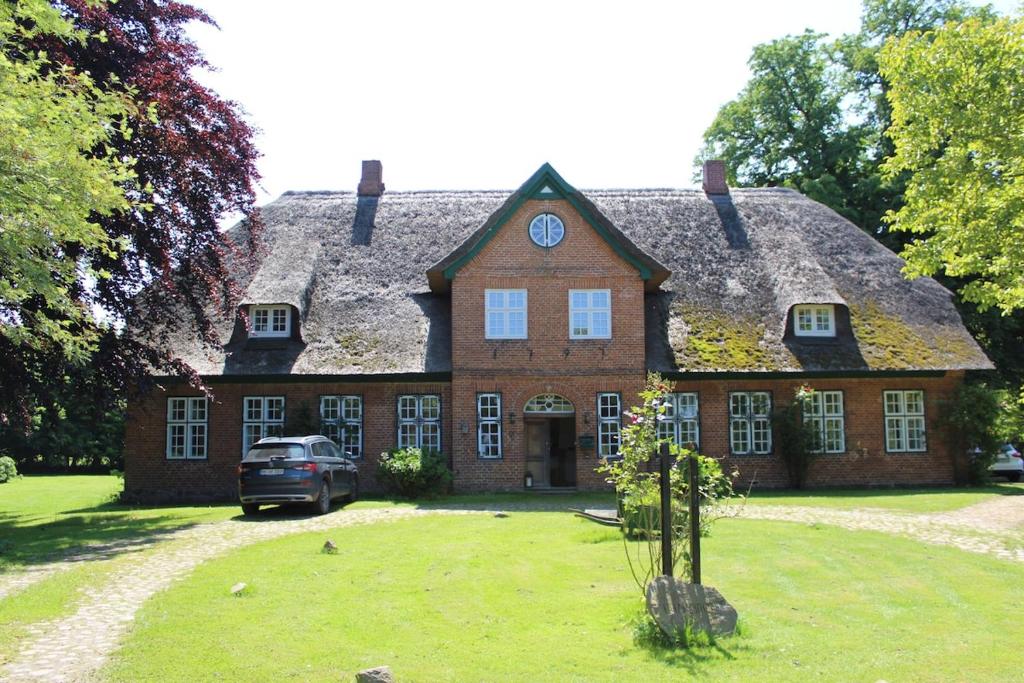 a large brick house with a car parked in front of it at Charlottenhof in Wangels