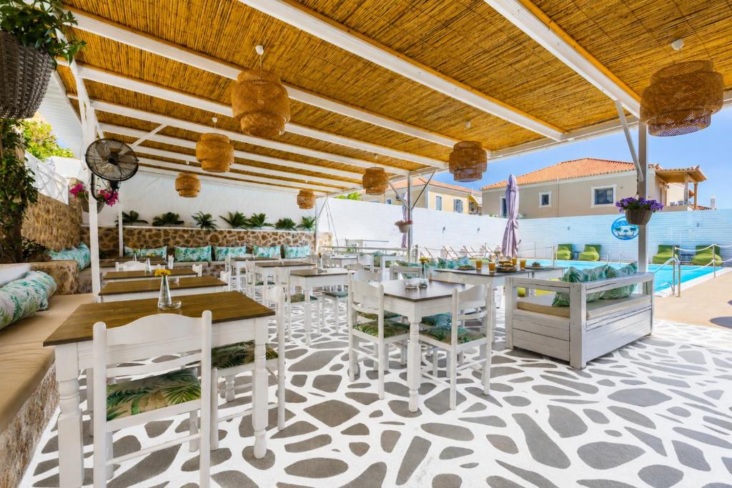 a restaurant with white chairs and tables on a patio at Bay's in Spetses