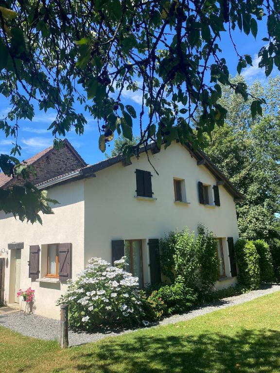 a white house with black windows and a yard at Liabaquet Gîtes in Sarlande