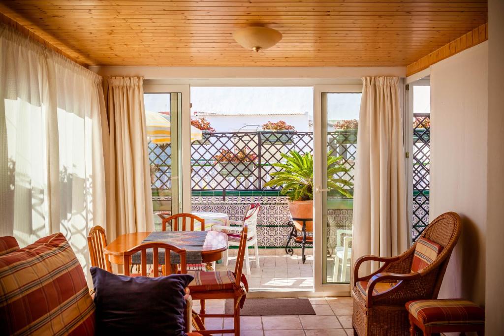 ein Esszimmer mit einem Tisch, Stühlen und einem Fenster in der Unterkunft Casa Charlotte in Nerja