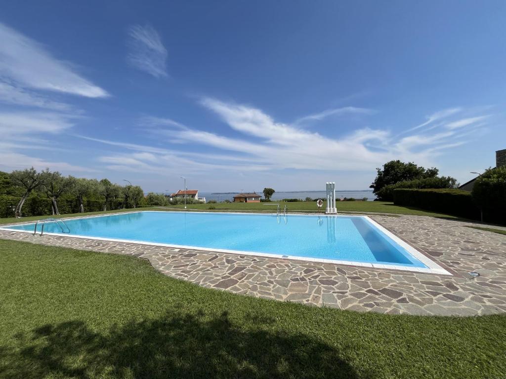a swimming pool in the middle of a grass field at Garda Prestige Retreat in Moniga