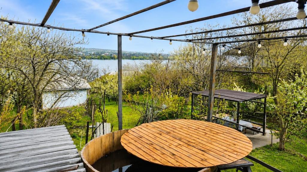 a wooden table sitting on a patio with a view of a lake at Casa Boierului (Viscauti) in Vîşcăuţi