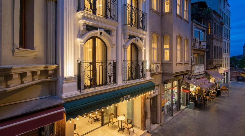 a building with tables and chairs on a street at night at Stern Hotel Karaköy-Special Class in Istanbul