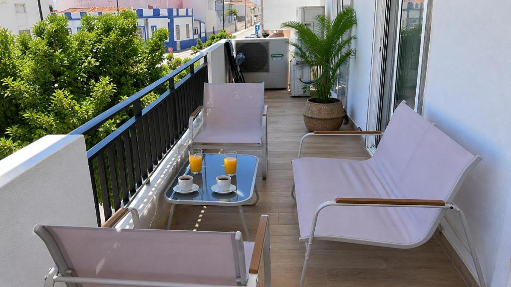 a balcony with two chairs and a tray of drinks at Casa Santos Faro Beach in FAO