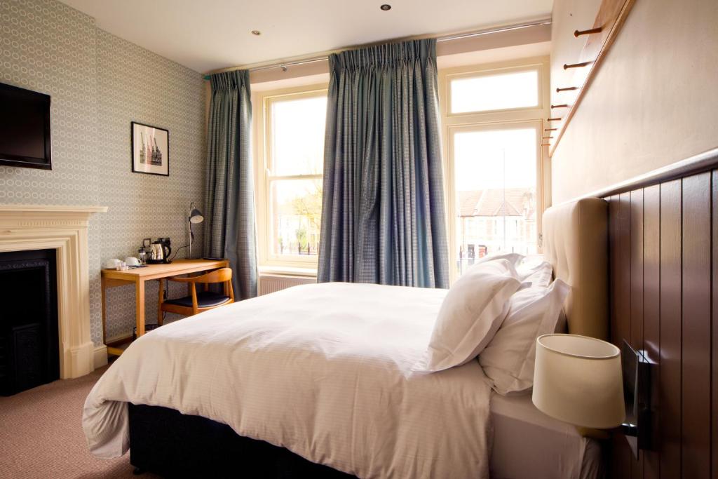 The Wellington في بريستول: غرفة نوم مع سرير أبيض كبير ومدفأة