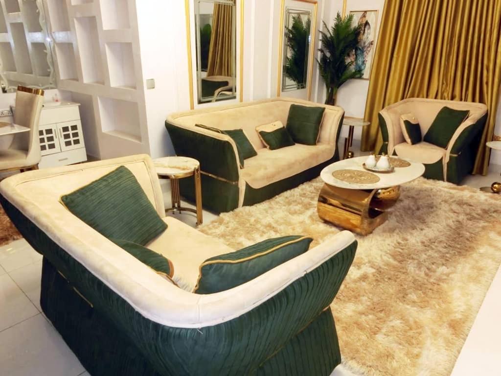 a living room with chairs and a couch and a table at P M Serviced Apartments in Lagos