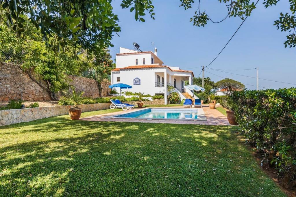 a house with a swimming pool in a yard at Casa Moura in Loulé