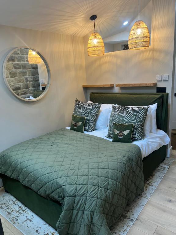 a bedroom with a green bed and a mirror at The Sanctuary Ashover in Chesterfield