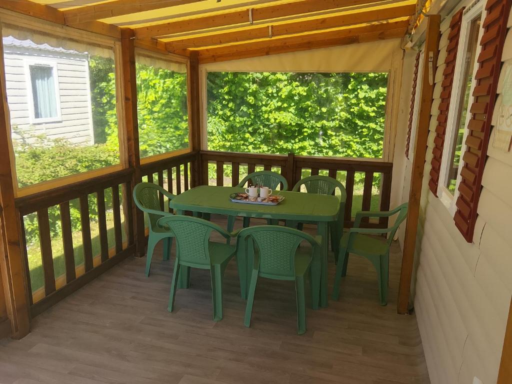 a screened in porch with a table and chairs at Séjour à litteau in Litteau