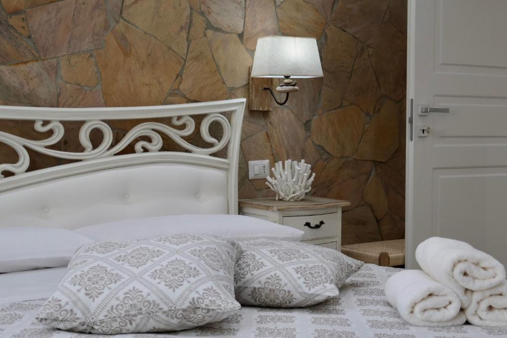 a bedroom with a white bed with towels on it at Sabbia e Coralli in Muravera