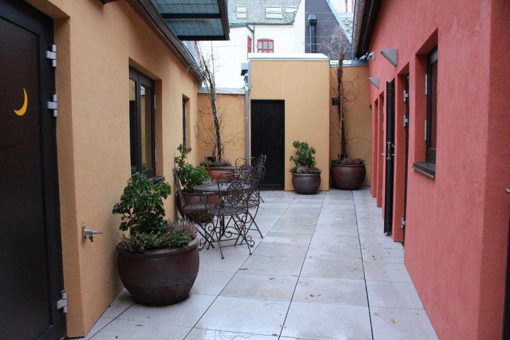 un cortile vuoto con sedie e piante in vaso di Home Again Apartments Nygata 16 a Stavanger