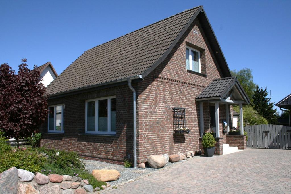 a red brick house with a black roof at Frey - Ferienhaus über zwei Etagen mit Terrasse in Eggebek