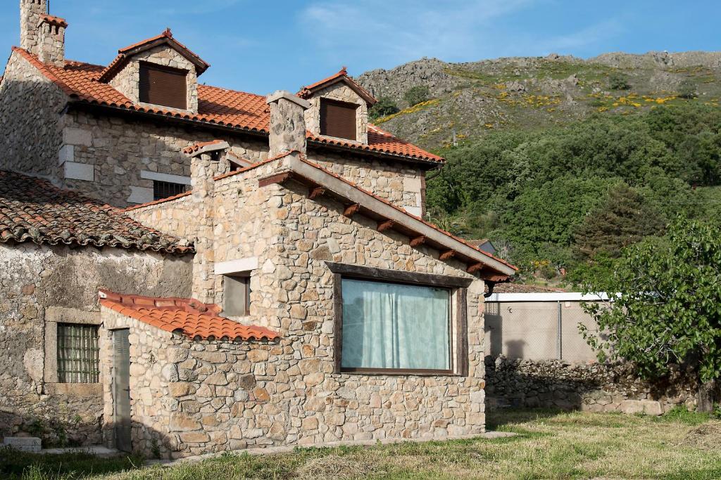 un edificio de piedra con una ventana en el lateral. en Casa Rural Romanejo, en Cabezabellosa