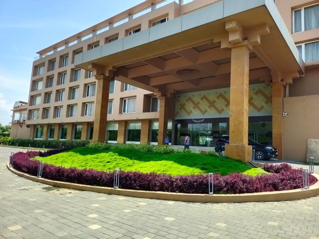 ein großes Gebäude mit einem grünen Rasen davor in der Unterkunft Devka Beach Resort in Daman