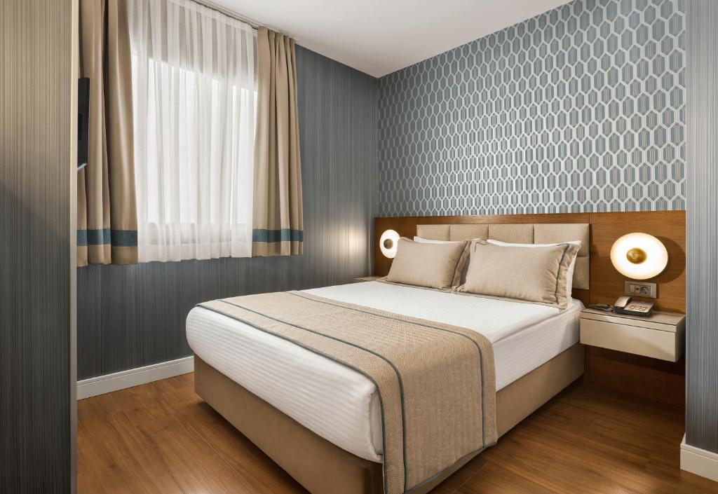 ein Schlafzimmer mit einem großen Bett in einem Zimmer in der Unterkunft The New Hotel Zeybek in Izmir