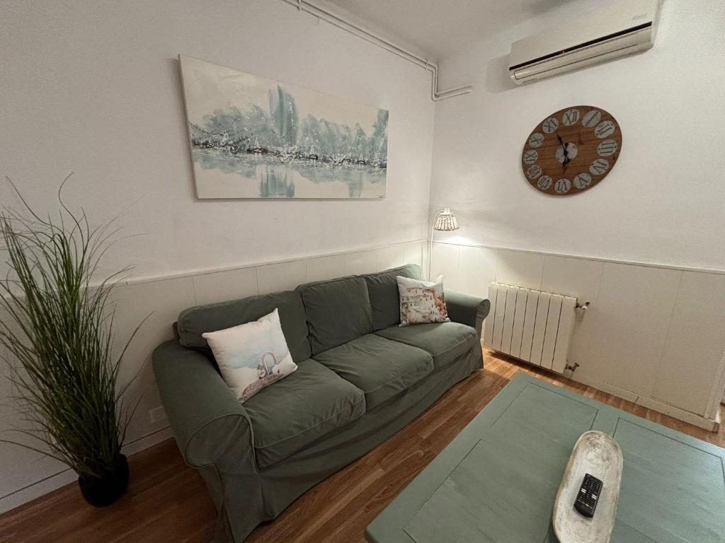 a living room with a couch and a clock on the wall at Vilasardemarlux2 in Vilassar de Mar