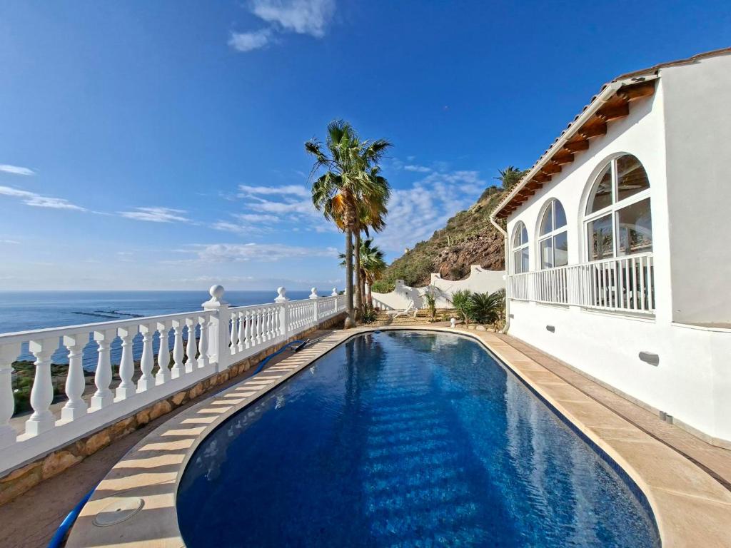 a villa with a swimming pool next to the ocean at Casa Mar II in Águilas