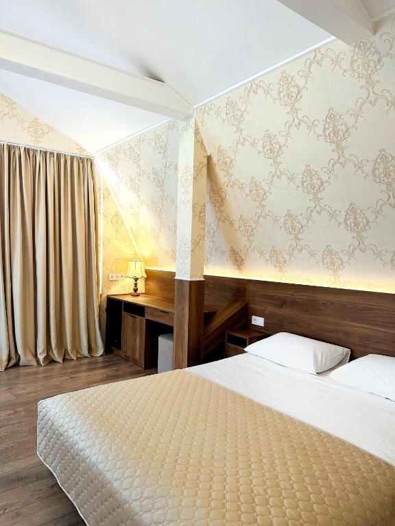 a hotel room with a bed and a desk at Hotel Plazma in Lviv
