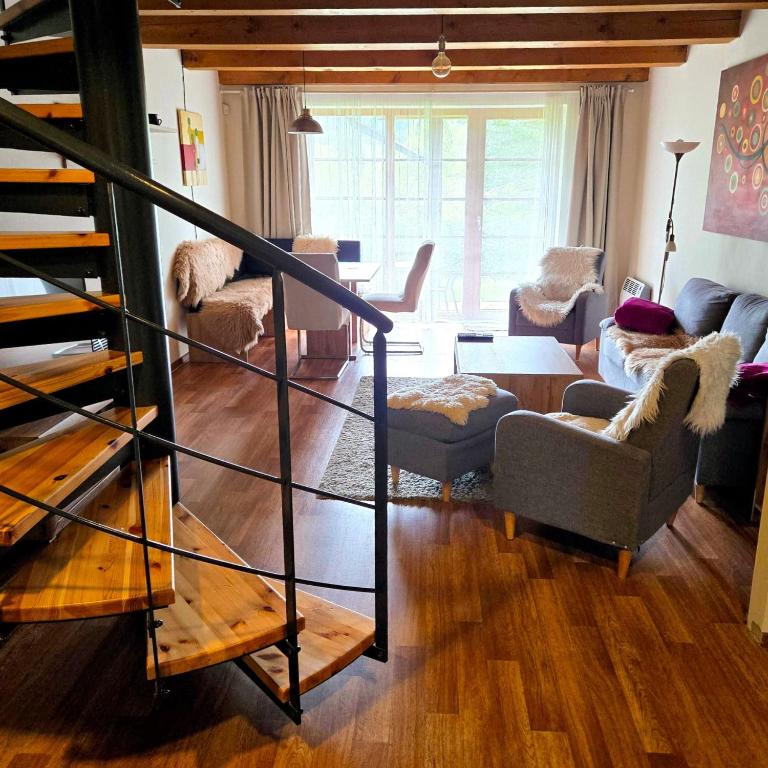 a living room with a spiral staircase and a living room at Apartmán Říčky 23 in Říčky