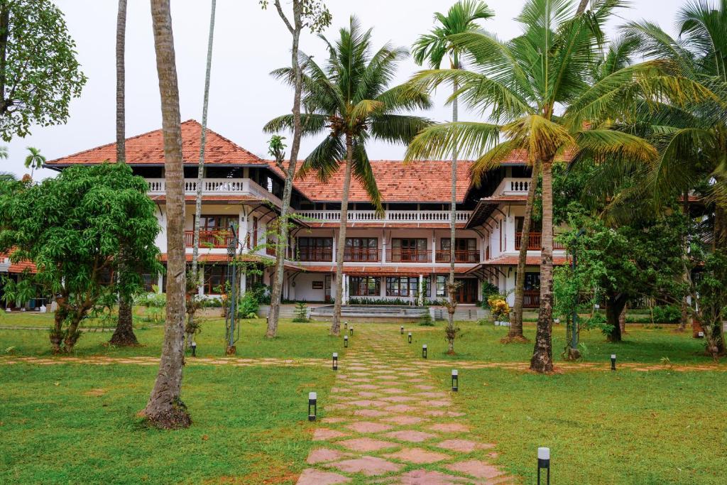 a large building with palm trees in front of it at Sanskreti in Cochin