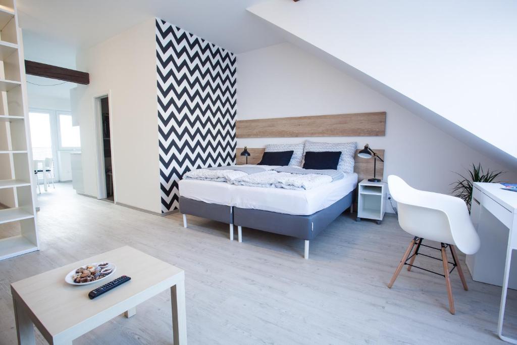 a bedroom with a bed and a desk and a chair at Haas Apartments in Brno