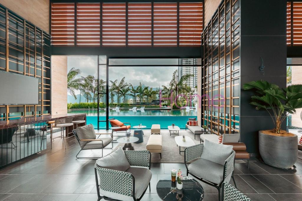 a hotel lobby with a pool and tables and chairs at Antharas 1 Premier Suites Genting Highlands in Genting Highlands