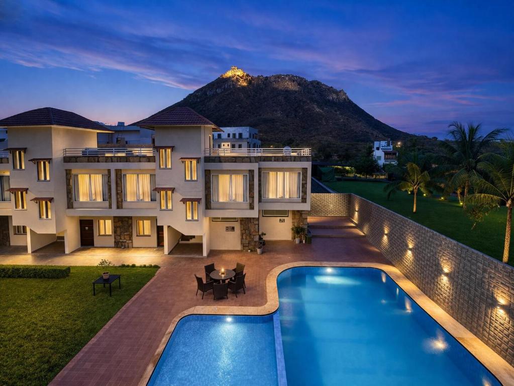 a villa with a swimming pool at night at Devi Palace - Monsoon Palace View Resort, Udaipur in Udaipur