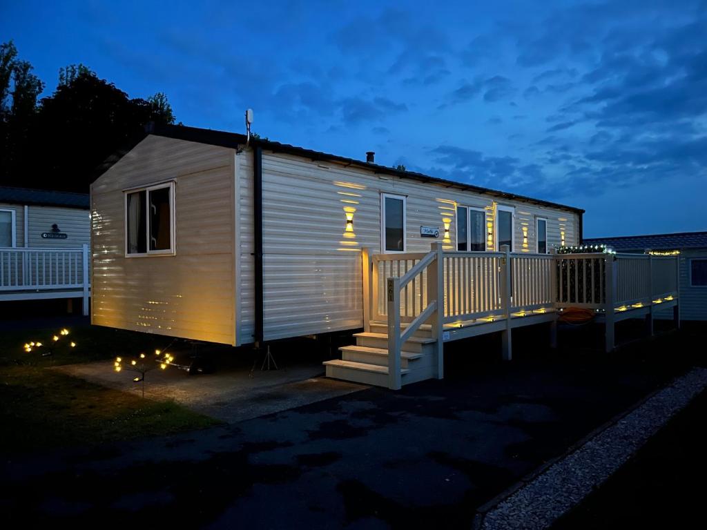 a tiny house with lights on it at night at Bang Tidy 261 - Cabin - Wifi - Pool - Sleep 6 in Paignton