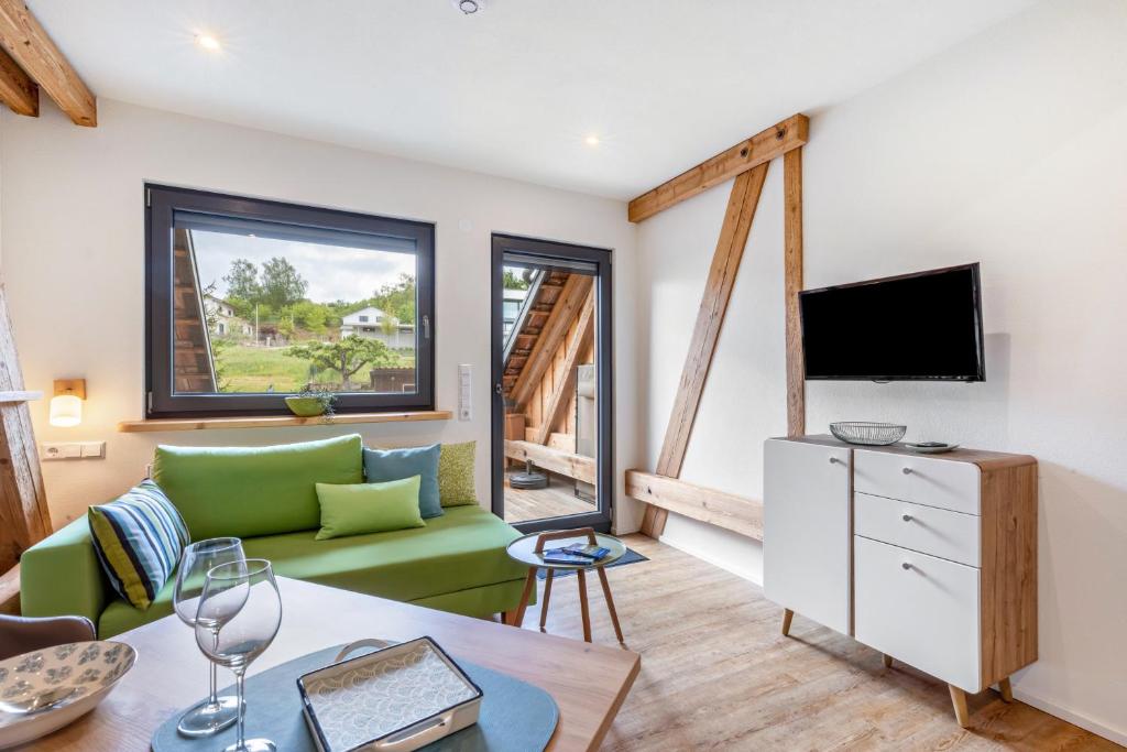 a living room with a green couch and a tv at Oberling in Herbrechtingen