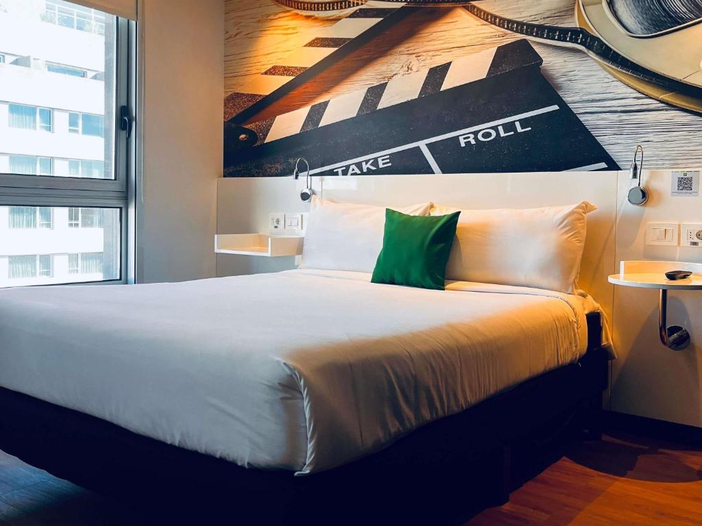 a bedroom with a large bed with a poster on the wall at ibis Styles Montevideo Biarritz in Montevideo