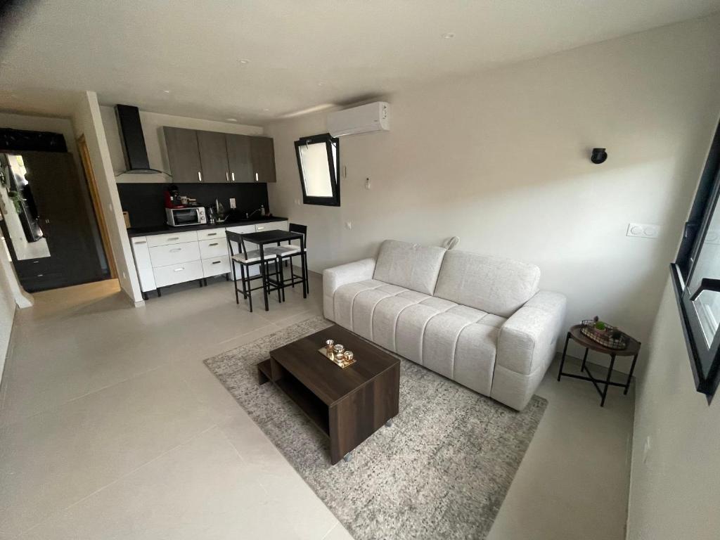 a living room with a white couch and a table at Studio cosy avec terrasse in Montpellier