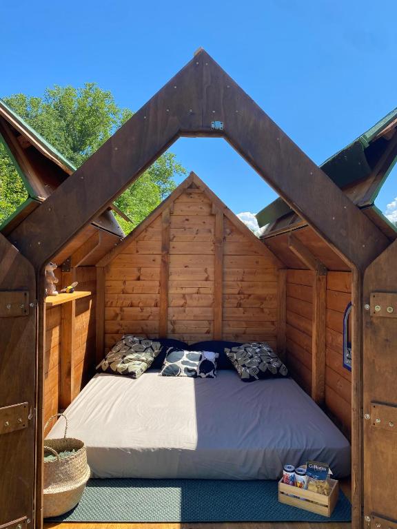 a bed in the inside of a wooden house at Altaluna tiny house sotto le stelle in Trebbiantico