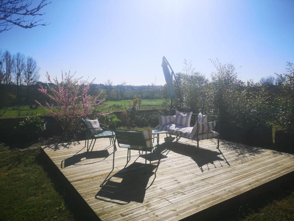 two chairs and a table on a wooden deck at Domaine des Bichettes in Mareuil-sur-Lay