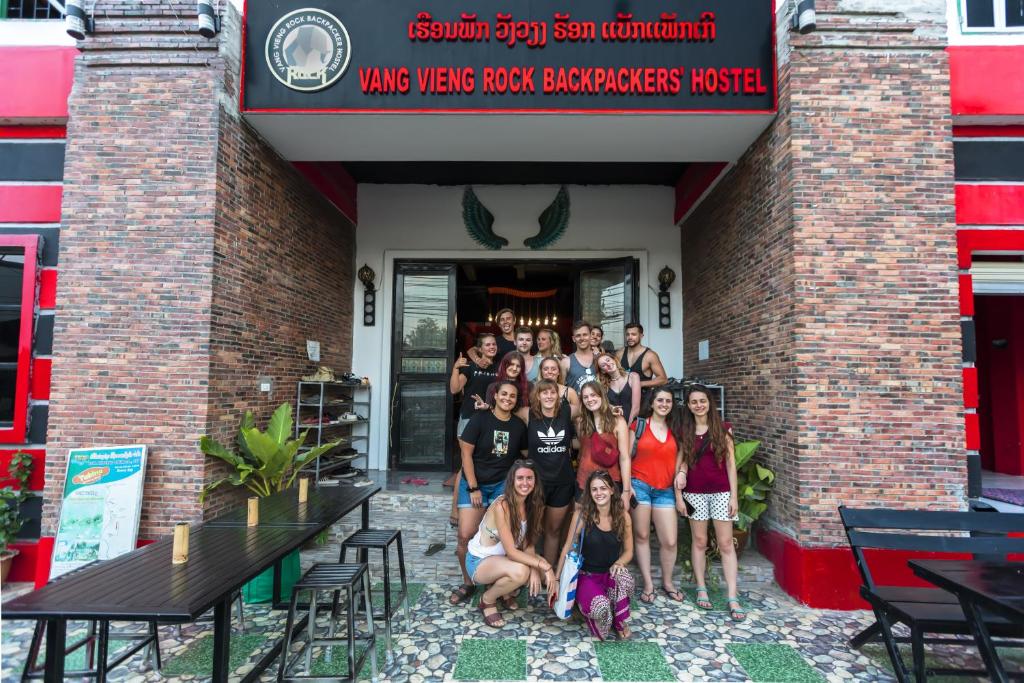 a group of people posing in front of a brick building at The Rock Monkey Hostel in Vang Vieng