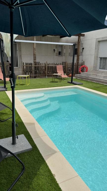 a large blue swimming pool with an umbrella at Finca cataleya in Noez