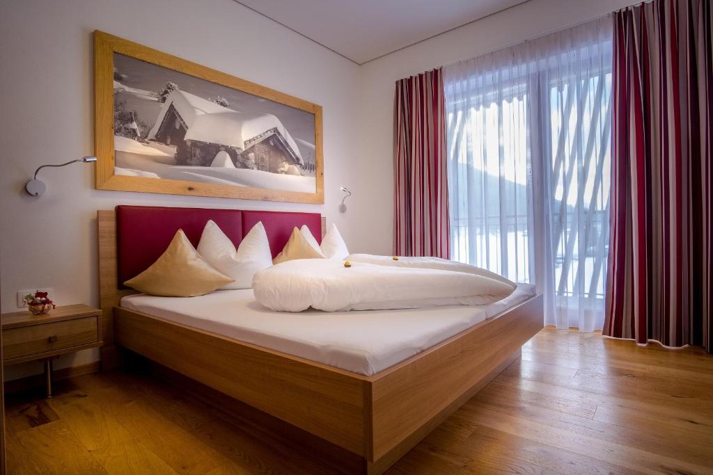 sypialnia z łóżkiem i dużym oknem w obiekcie Apartments Dolomit-Royal w mieście Sillian