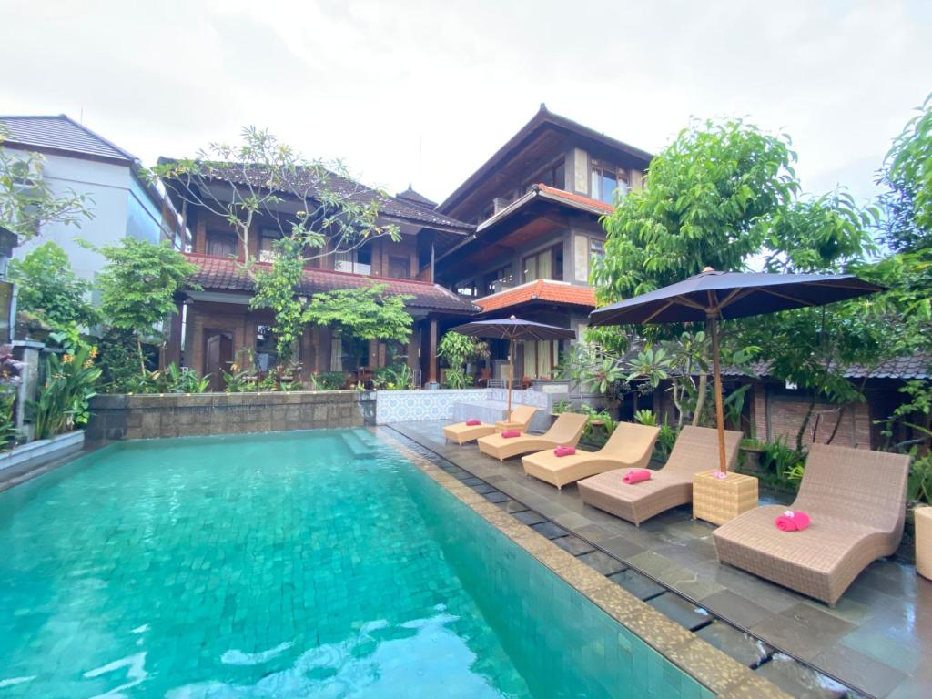 a villa with a swimming pool and a resort at Dewa Bungalows, A Balinese House and Art Gallery in Ubud