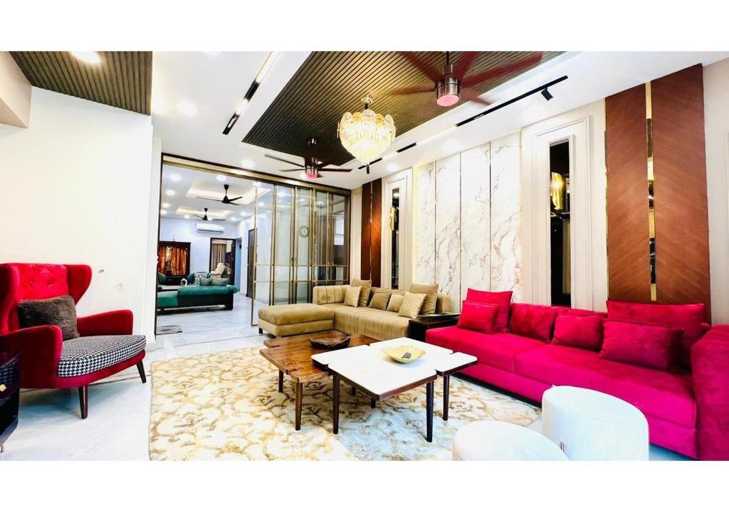 a living room with a red couch and a table at Olive Serviced Apartments - Central Delhi in New Delhi