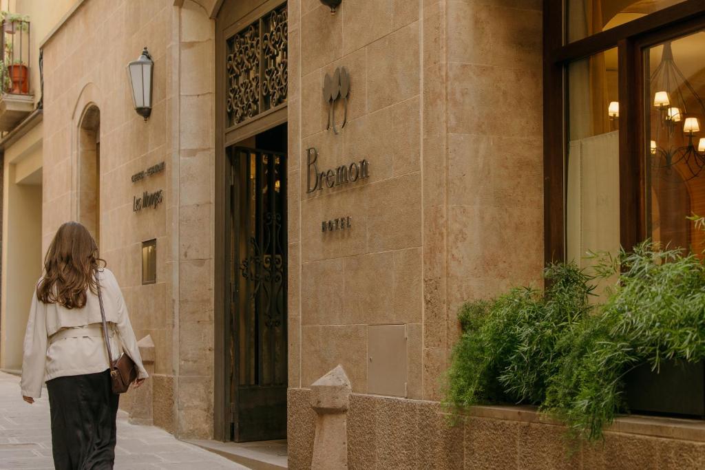 a woman walking in front of a store at Hotel Bremon by Grup Duquessa in Cardona