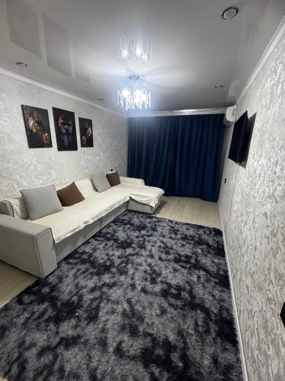a living room with a couch and a large rug at Квартира 2 комнаты in Balqash